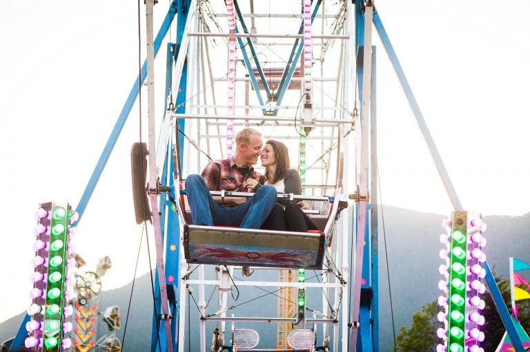engaged couple riding a ferris wheel