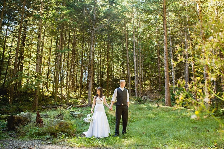 bride and groom holding hands in woods