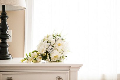 bridal bouquet sitting on a bed side table