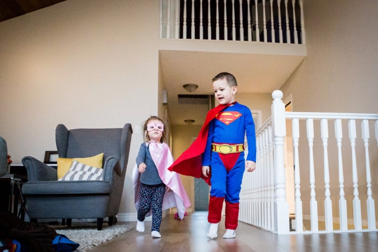 children dressed as superheroes photographed in an even window light
