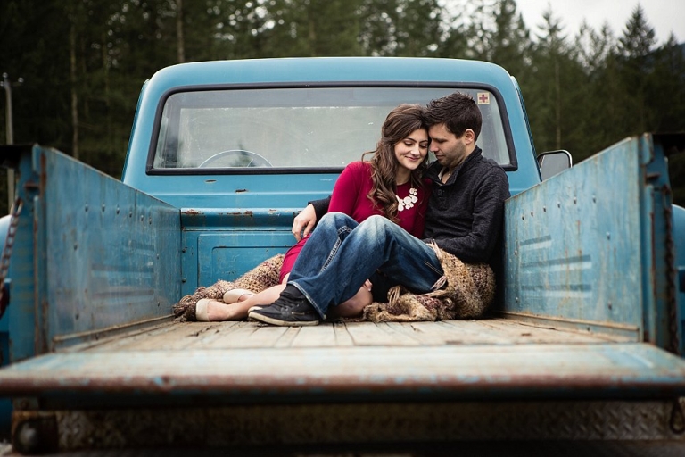 boy and girl snuggling in the box of an old truck