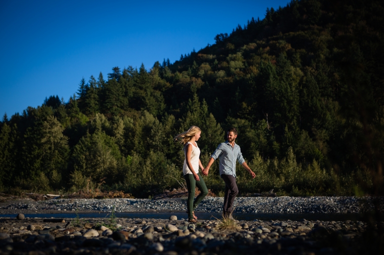 an engaged couple walking along the vedder river