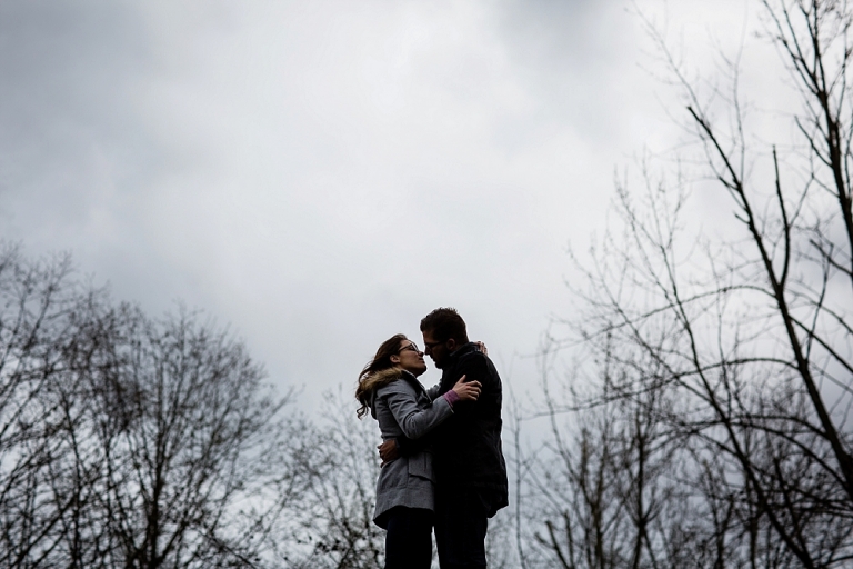 silhouette of a couple almost kissing in front of the sky