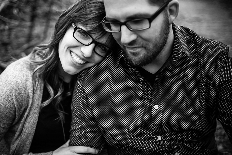 black and white photo of engaged couple snuggling