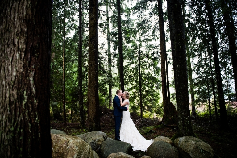 bride and groom kissing in the forest at whonnock lake centre