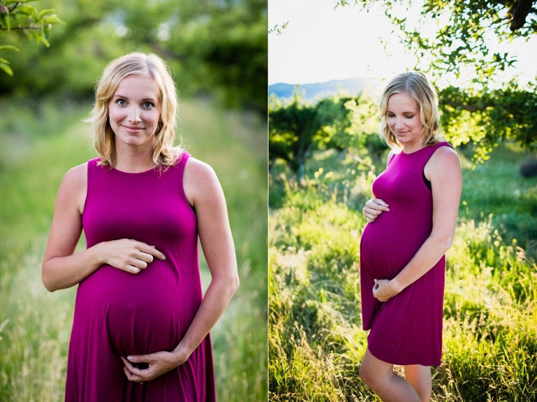 pregnant woman standing in an orchard with a pink dress