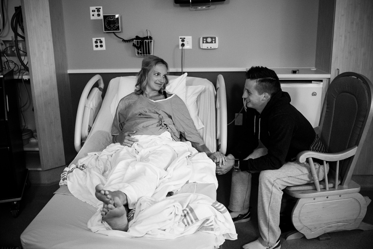 husband and wife holding hands during labor