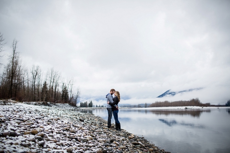 engaged couple hugging by the fraser river